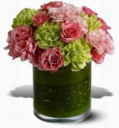 Mix of roses and carnations in shades of pink and green and leaflined vase