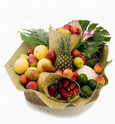 Fruit Basket of 1 Pineapple, 12 peaches, 6 Pears, 4 Advocados, 3 Fuji Yellow Apples, 2 red Apples, 12 Strawberries surrounded by large leaves.