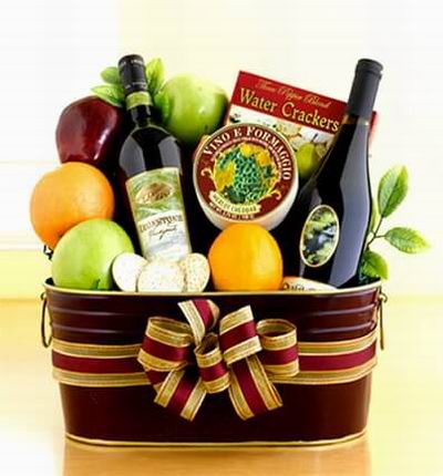 Fruit Basket of 2 oranges, 2 green Apples, 1 red Apple, Crackers, Cheese and two bottles of red Wine.