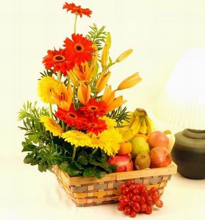 Flower basket of 10 yellow lily buds, 6 orange Gerbera Daisies, 6 yellow Gerbera Daisies, greenery, 4 Bananas, 3 Pomogranates, 2 Kiwis, 2 Tangerine Oranges and Globe Grapes. If the tulips are not available, it will be substituted with Roses.