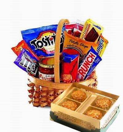 A box of Standard Mooncakes and a Basket of serious snacks. Doritos chips, Crunch chocolate bar, Butterfinger bar, packaged Chocolate cake roll, Crackers with cheese (Ritz), Salsa Sauce for the Chips, M&Ms, Reese's candy and Potato Chips.