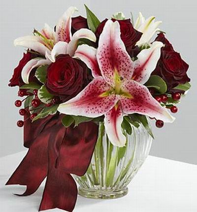 6 Dark red roses and 3 Stargazer lilies.
