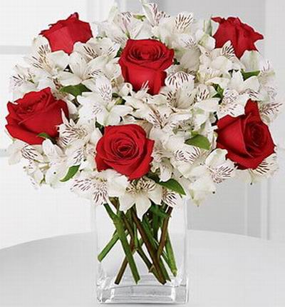 6 red roses, snowy white Peruvian lilies accented with Israeli ruscus greens.