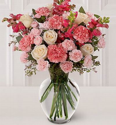 A warm pink theme of 18 Carnations, 6 Roses, fillers and greenery