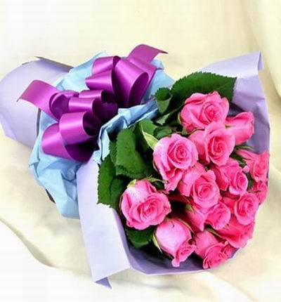 12 pinked packed Roses with greenery.