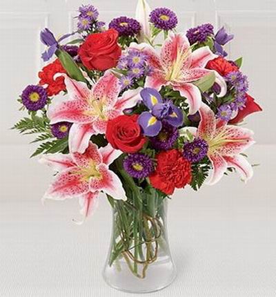 6 red Roses, 4 pink Lilies, 8 purple  Asters, 3 purple Iris and greenery.