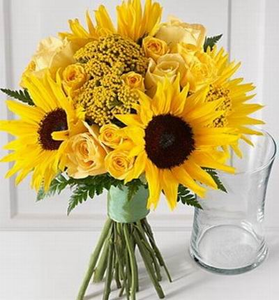 4 Sunflowers, 11 champagne/peach color Roses with Solidago fillers with a vase included.