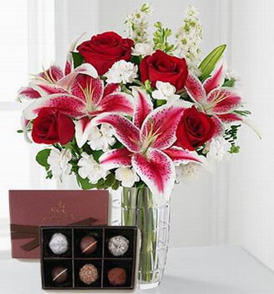 4 red Roses, 4 pink Lilies, white blossom fillers and a box of Godiva Truffles (6 pcs).