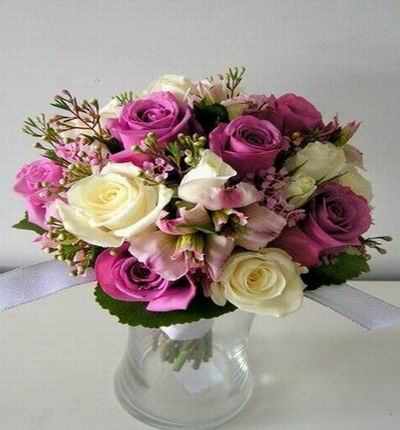 Bouquet of purple and white Roses with fillers.