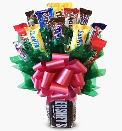 Send the sweetest of all gifts for a special occasion with this Chocolate Candy Bouquet. The bouquet has a vase designed that is made with real candy bars. Instead of flowers this vase is filled with a variety of your favorite chocolate treats from Twix to Milky Ways and Kit Kat bars. The candy flower bouquet is completed with a colorful bow which makes this gift pop with color. The Bouquet is delivered wrapped in a cellophane bag and tied with a red ribbon. The gift stands 14
